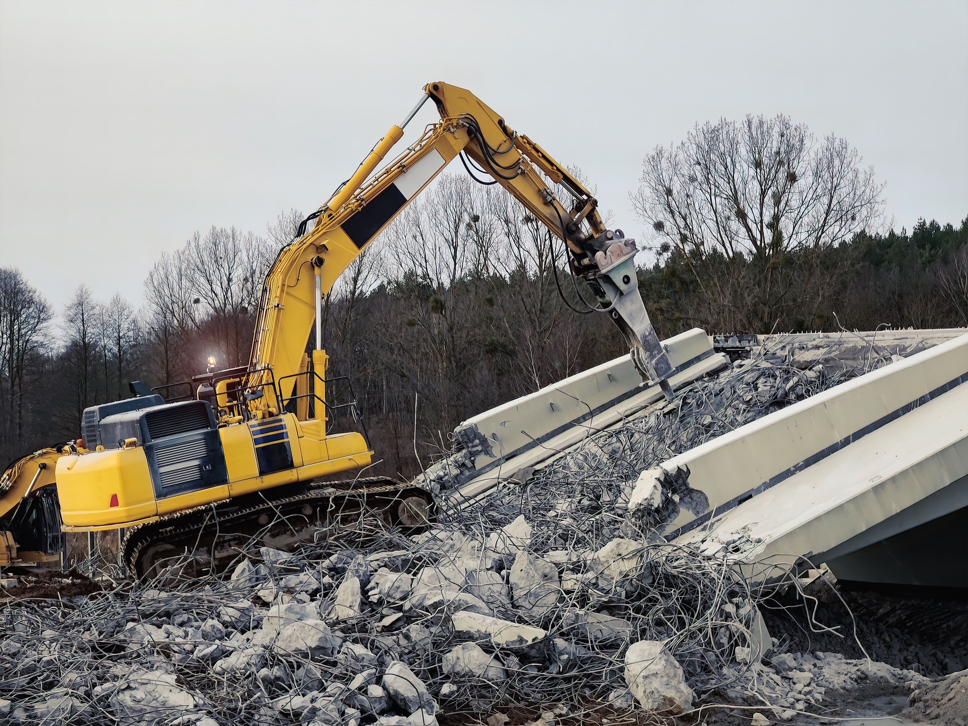 Excavator destructing bridge