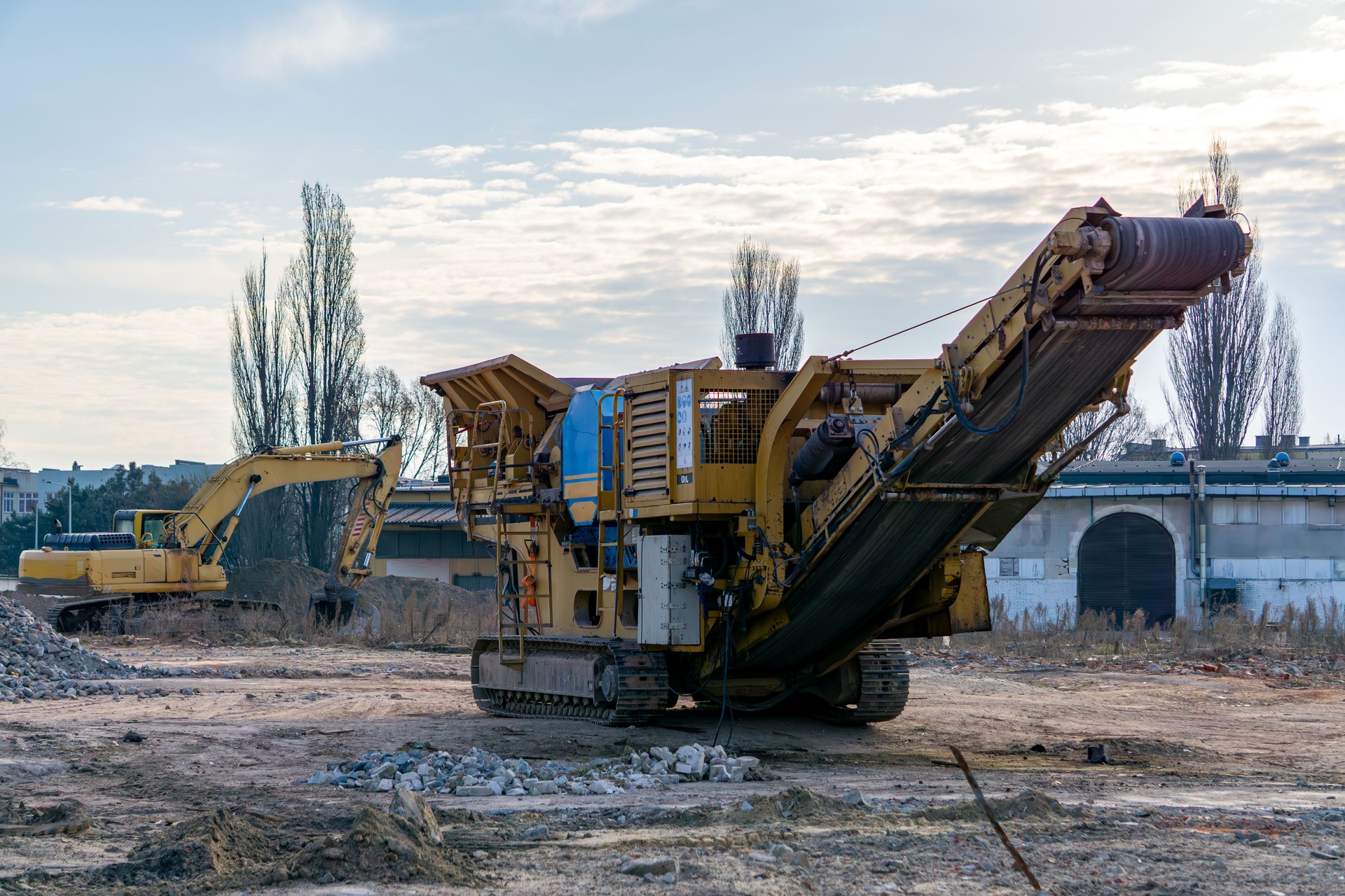 jaw crusher. construction machinery. Demolition of a residential building in the city center made of old red brick using a hydraulic excavator. lying brick on the ground. pile of earth. marking and marking of construction and road works